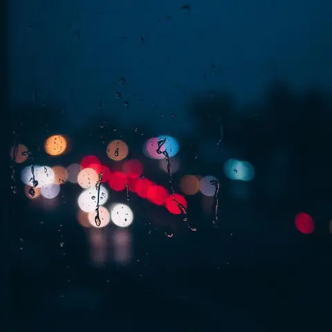 Rainy window with city lights